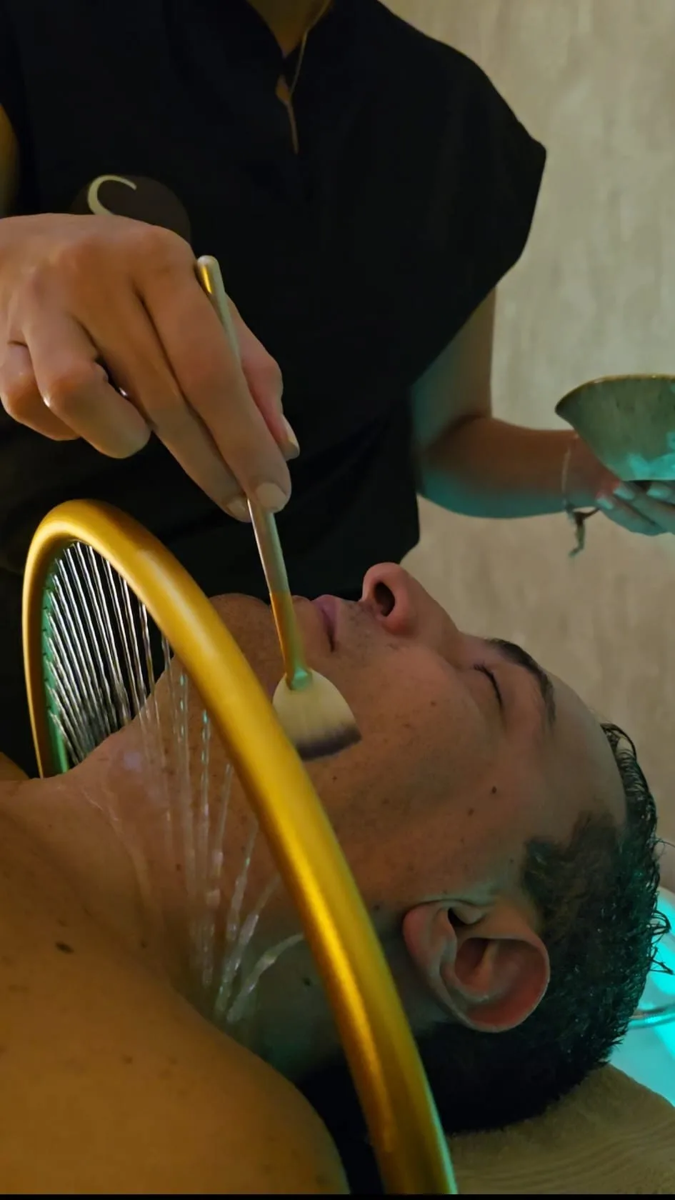 Aplicación de un producto durante el cuidado facial de un cliente en Simone.
