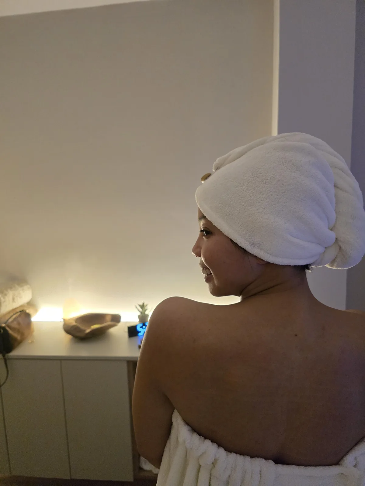 Una clienta con una toalla en el cabello disfruta de la atmósfera cálida de Simone.